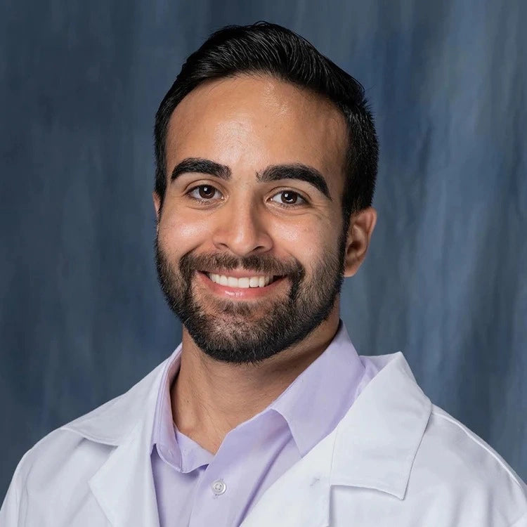 Dr. Cyrus Vahdatpour MD, board-certified dermatologist in white coat